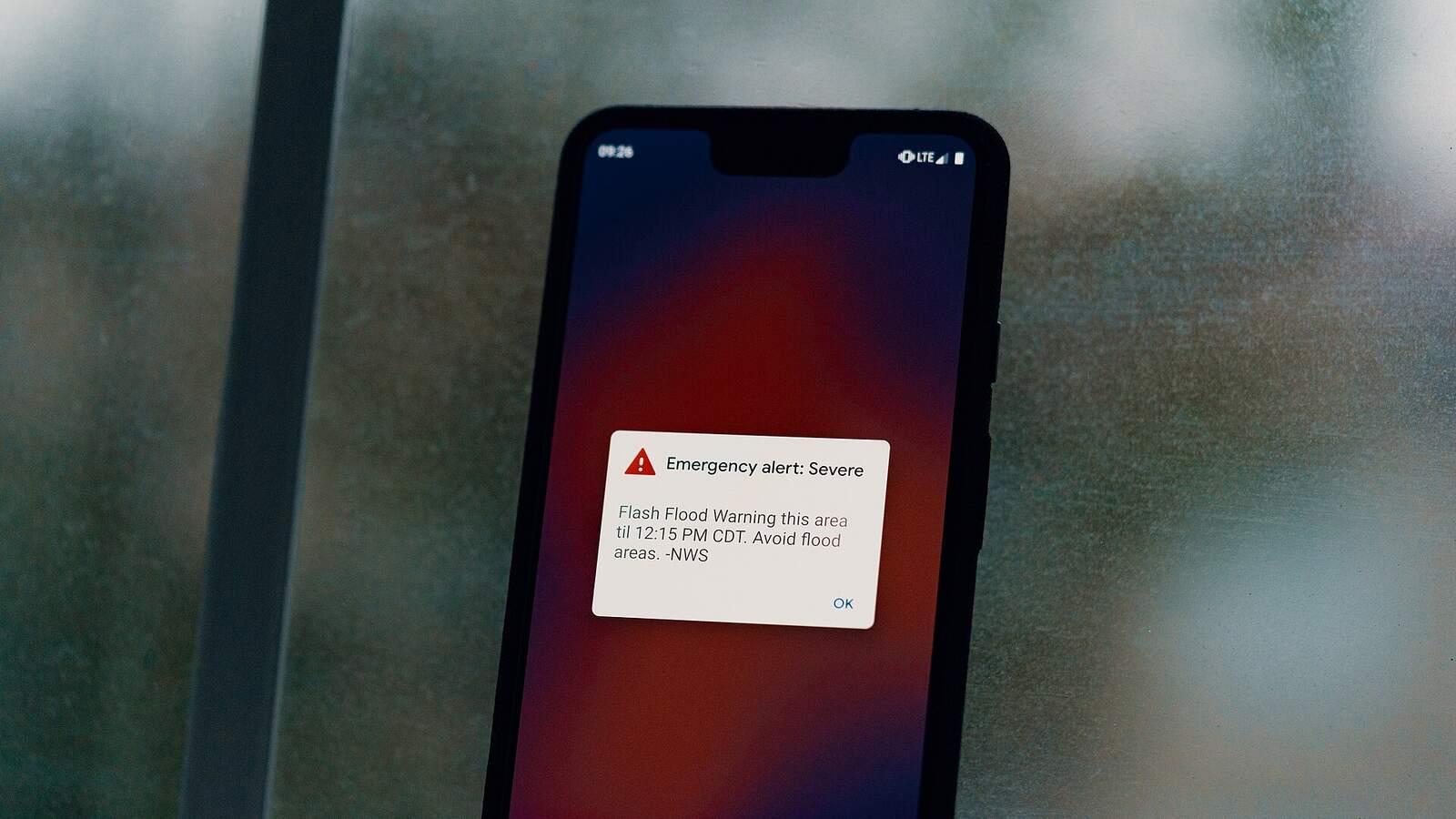 Smartphone affichant une alerte d'urgence aux crues soudaines, reçue aux États-Unis